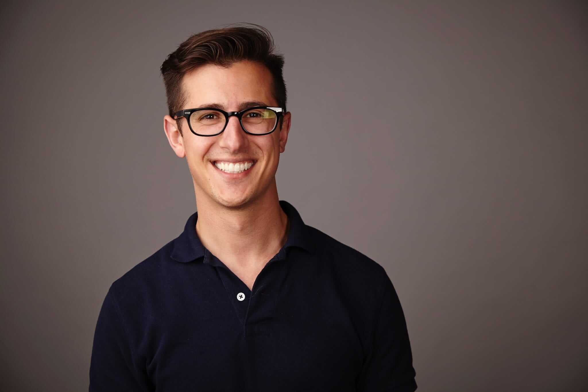 A portrait photograph of Brandon smiling.
